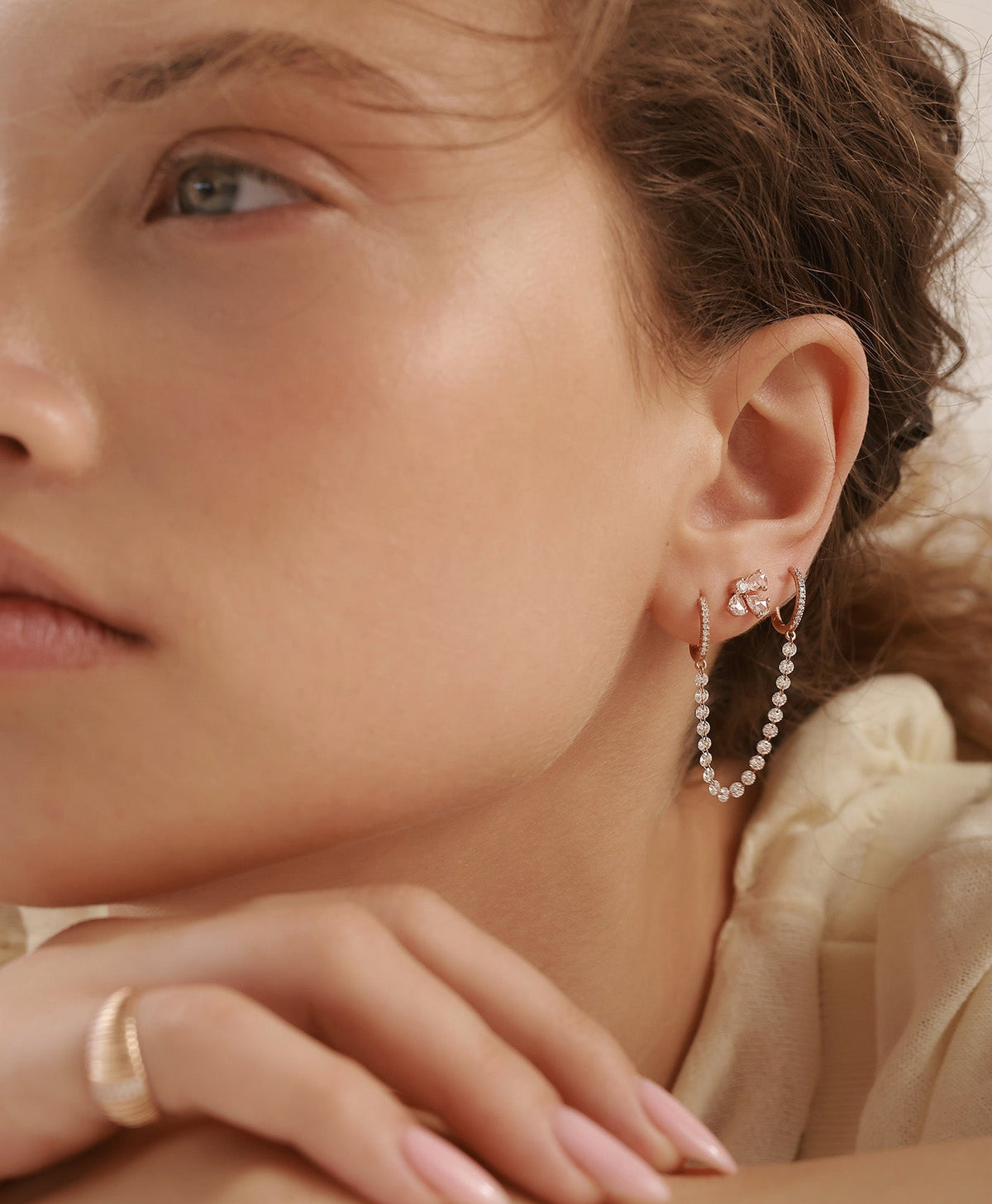 GIA rose gold diamond earring styled with MIA diamond earring in layered ear composition on model