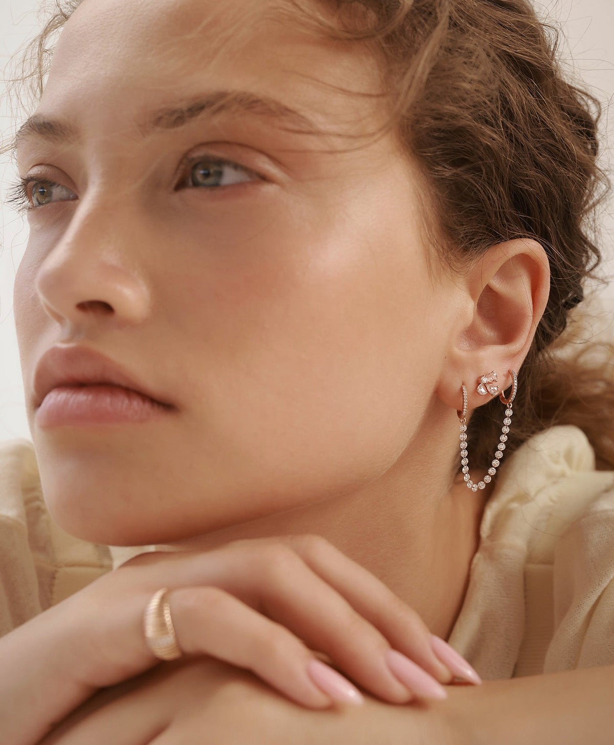 TWIN double hoop earrings in rose gold connected by a chain of floating natural rose cut diamonds, worn on model in a curated ear composition