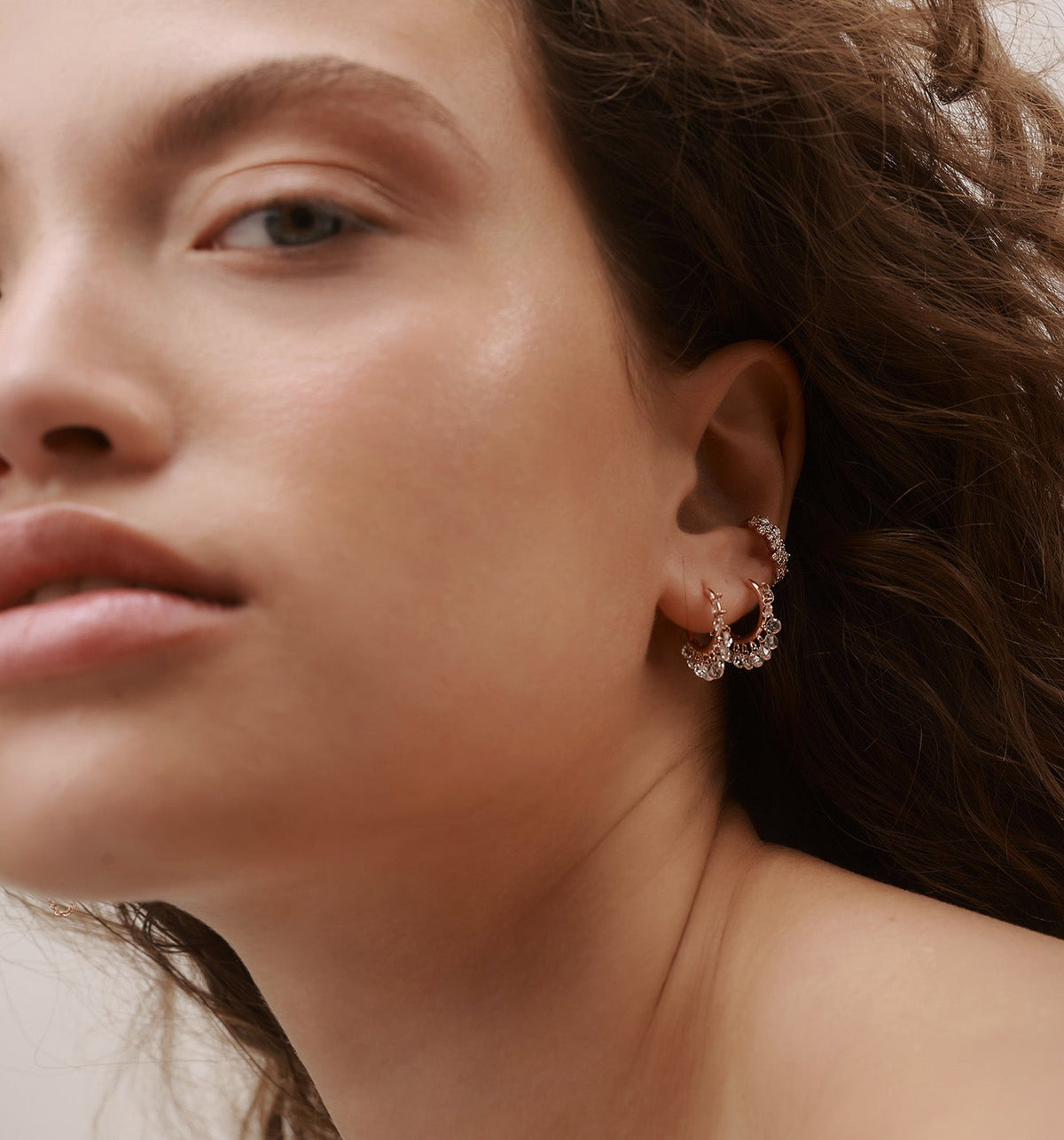 ZAZA floating diamond earrings in rose gold worn in two lobe piercings on model, featuring natural floating diamonds in a curated ear composition